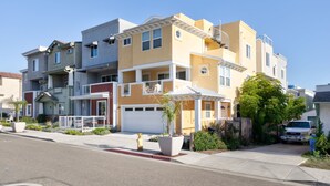 A multi-story residential building with a garage, a fire hydrant, and a parked truck.