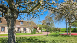 A traditional building with a brick facade, a paved courtyard, and a well-maintained lawn.