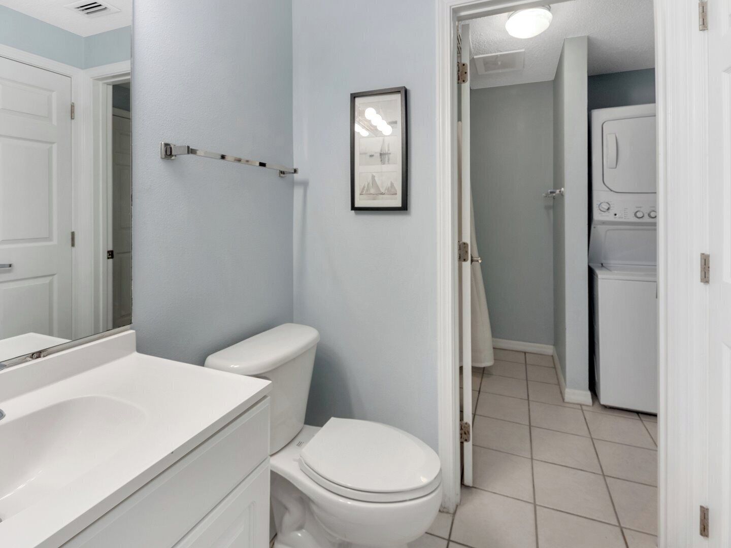 A bathroom with a toilet, a sink, and a mirror.