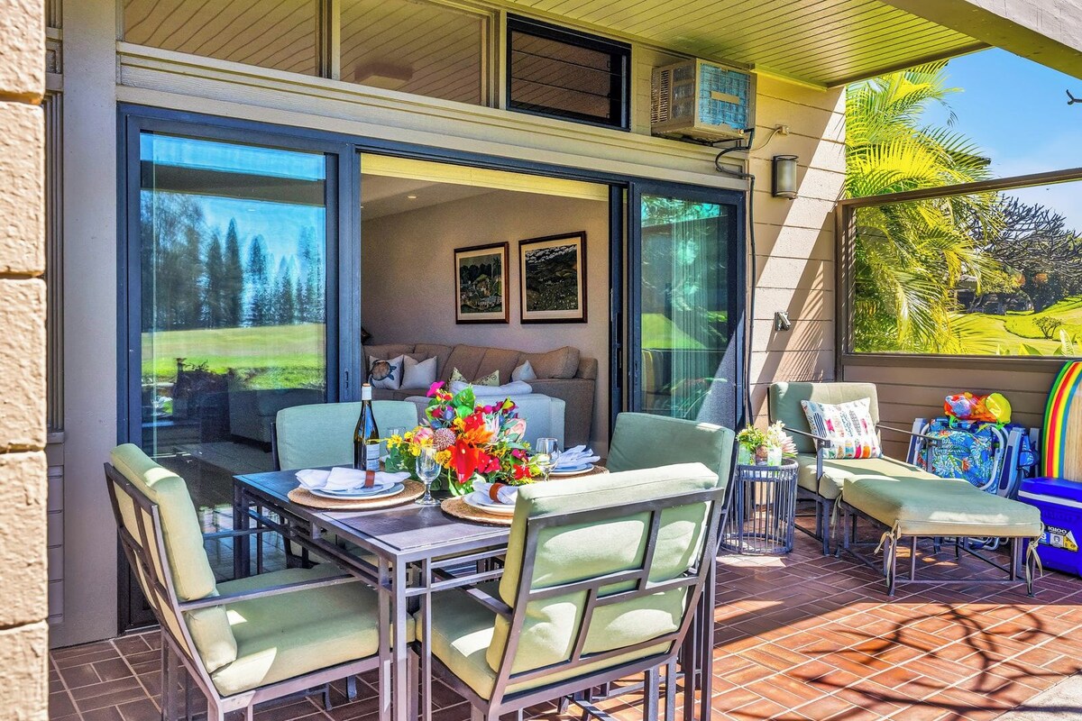 An outdoor dining area with a table set for two, chairs, and a sofa.