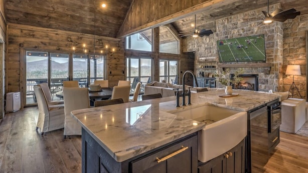 A spacious kitchen with a large island, stone walls, and a fireplace. - Changes In Altitude - Mountain Luxury | 4 Master Suites | Panoramic Views (Mineral Bluff)