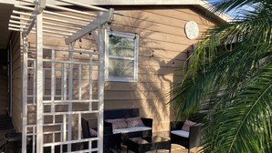 En täckt uteplats med utemöbler och en pergola.