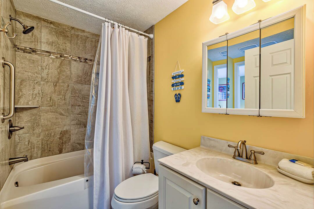 A bathroom with a bathtub, toilet, and sink.
