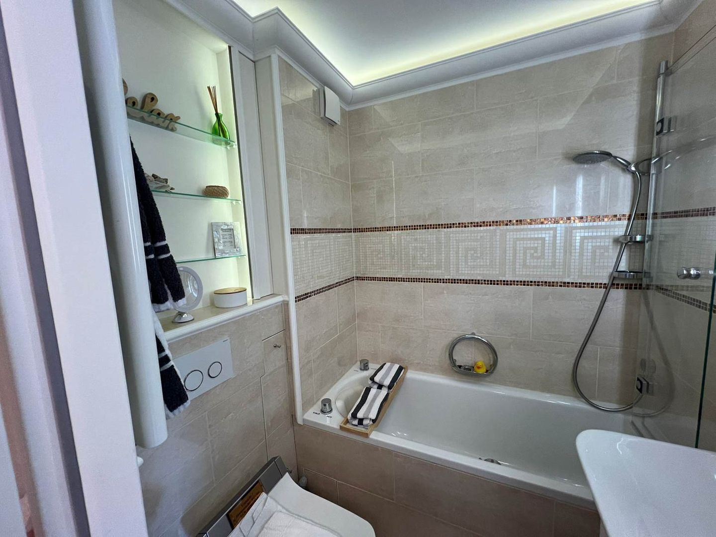 Un baño moderno con cabina de ducha de vidrio, bañera y tocador con espejo.