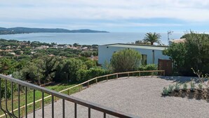 Ein Küstenanwesen mit Meerblick, ein modernes Gebäude und ein Kiesbereich mit Pflanzen.