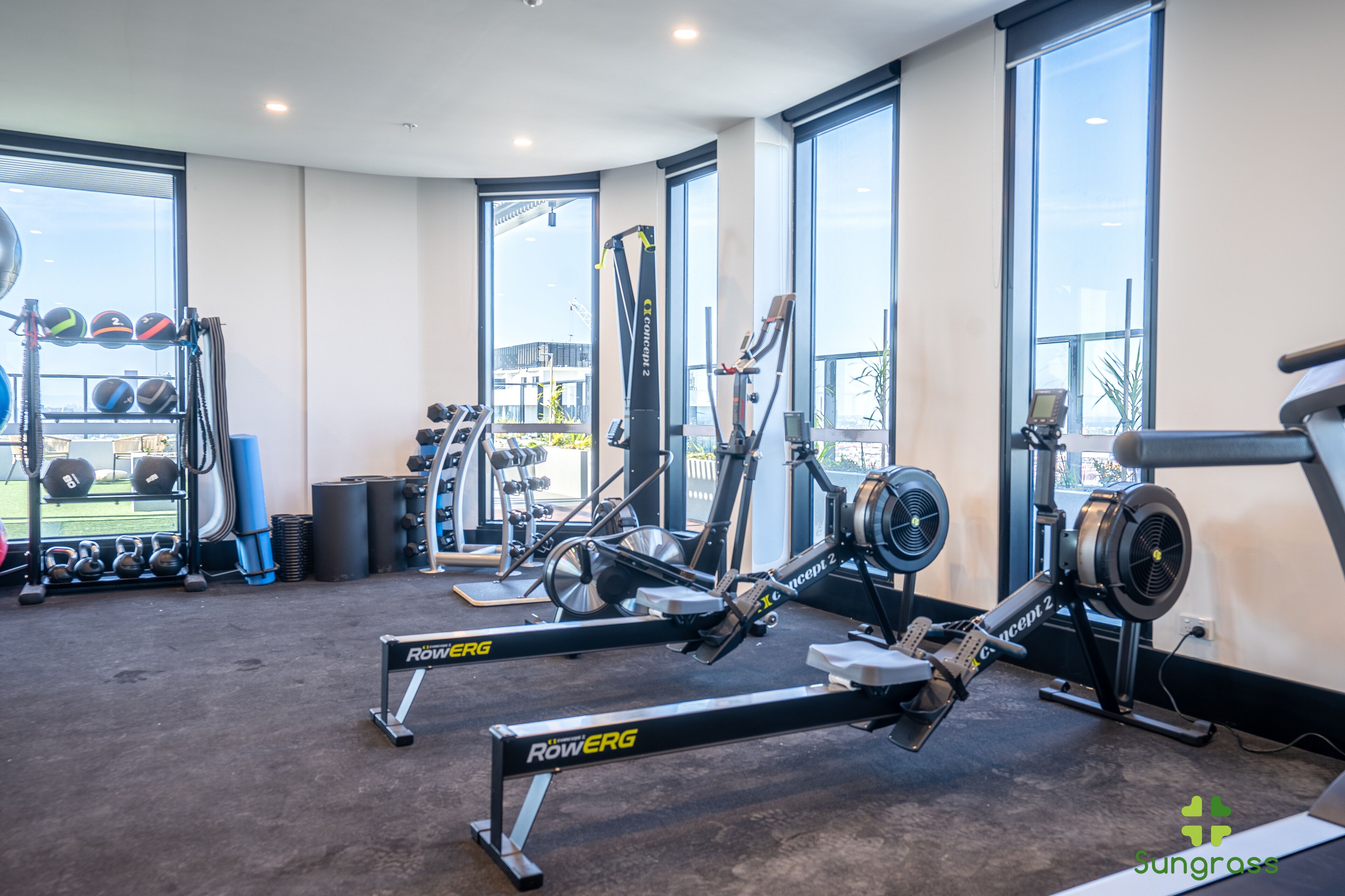 A gym with rowing machines, weight benches, and various exercise equipment.