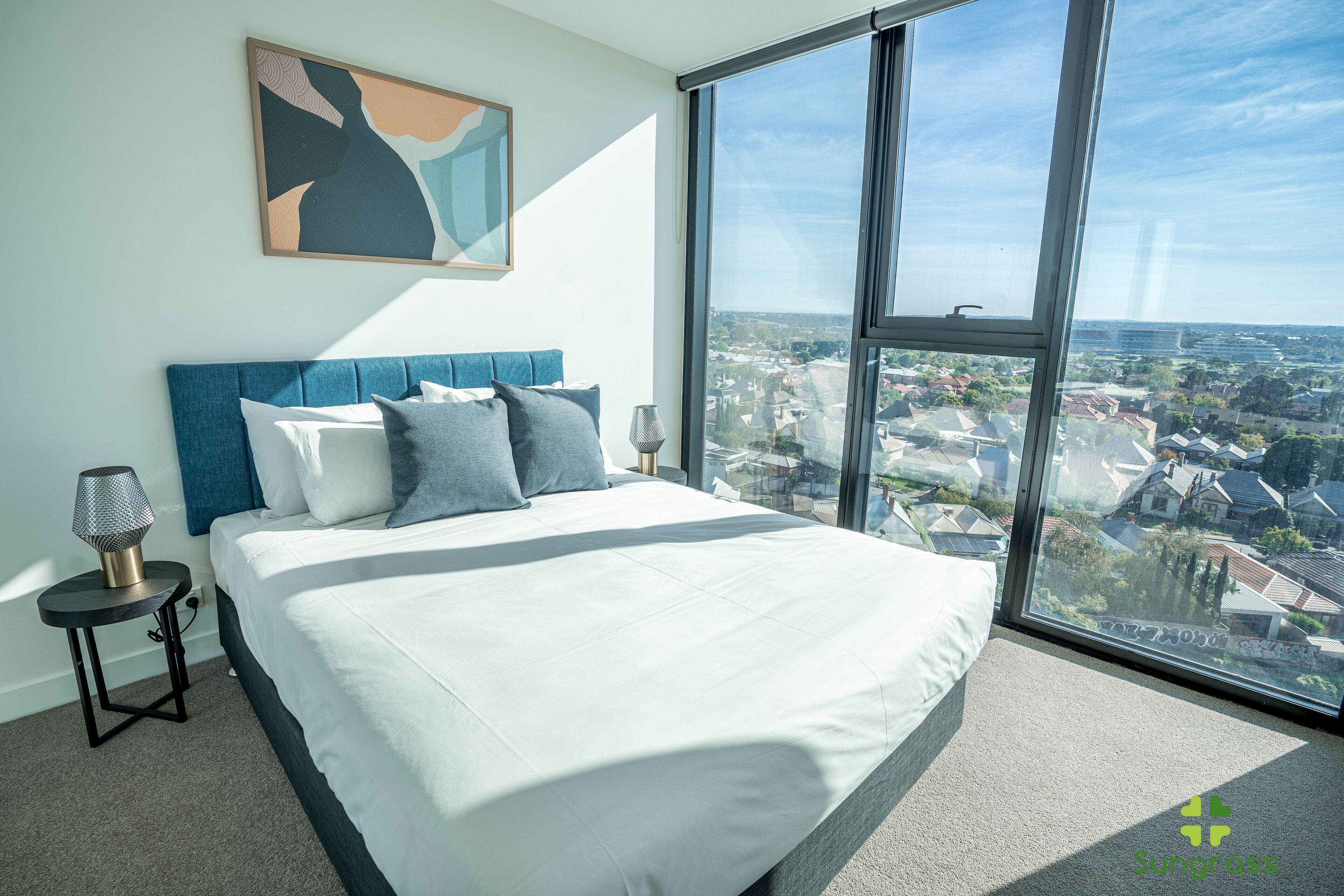 Una camera da letto con un letto grande, vista sulla città e una lampada moderna.