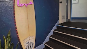 Een surfplank, een bord met daarop 'love' in neonletters, en een trap.