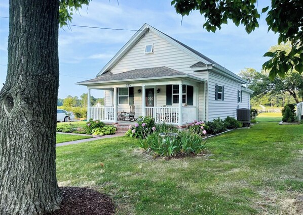 A single-story house with a front porch, a small attached garage, and a well-maintained lawn.