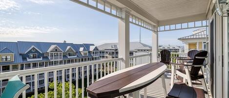 A covered outdoor area with a wooden deck, a table, and chairs.