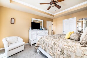 A bedroom with a bed, a white dresser, a ceiling fan, and a door. - Mini Weeks Stays Available Sunset Island 37 Founta (Ocean City)