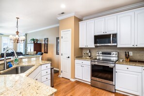 A kitchen with white cabinets, a stainless steel oven, and a granite countertop.