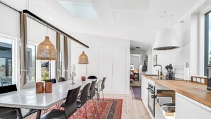 Une cuisine moderne avec des meubles blancs, un plan de travail en bois et un tapis à motifs rouges.
