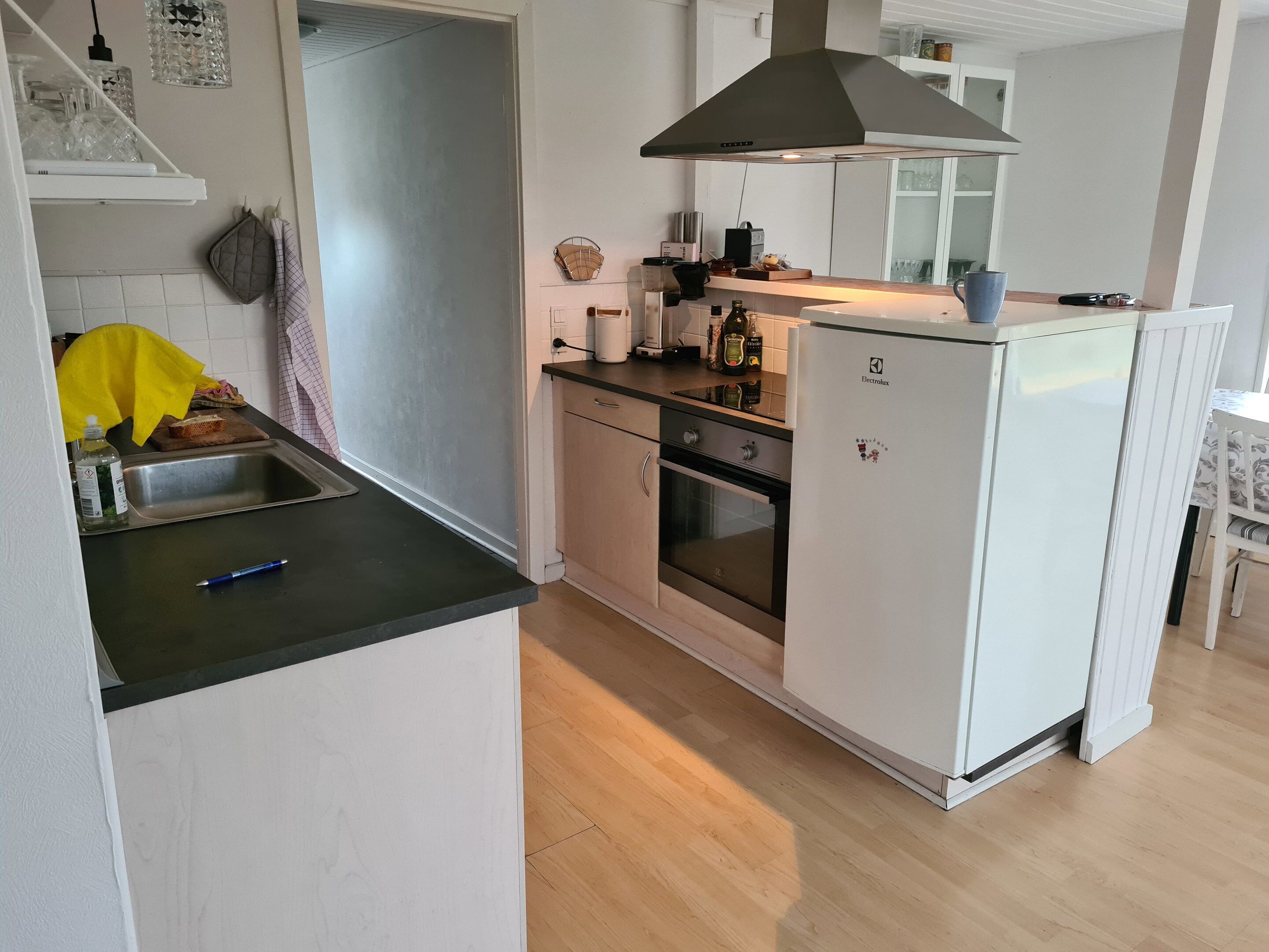 A compact kitchen with a sink, stove, oven, and a refrigerator.