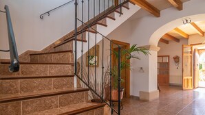 A staircase with a metal railing, leading to a room with a wooden door and a window. - NA BURGUERA - Wonderful villa with private pool and free WiFi. (Santanyí)