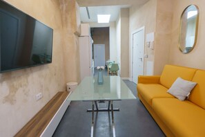 Relax in this modern space with a flat-screen TV, glass-top table, and comfortable sofa.