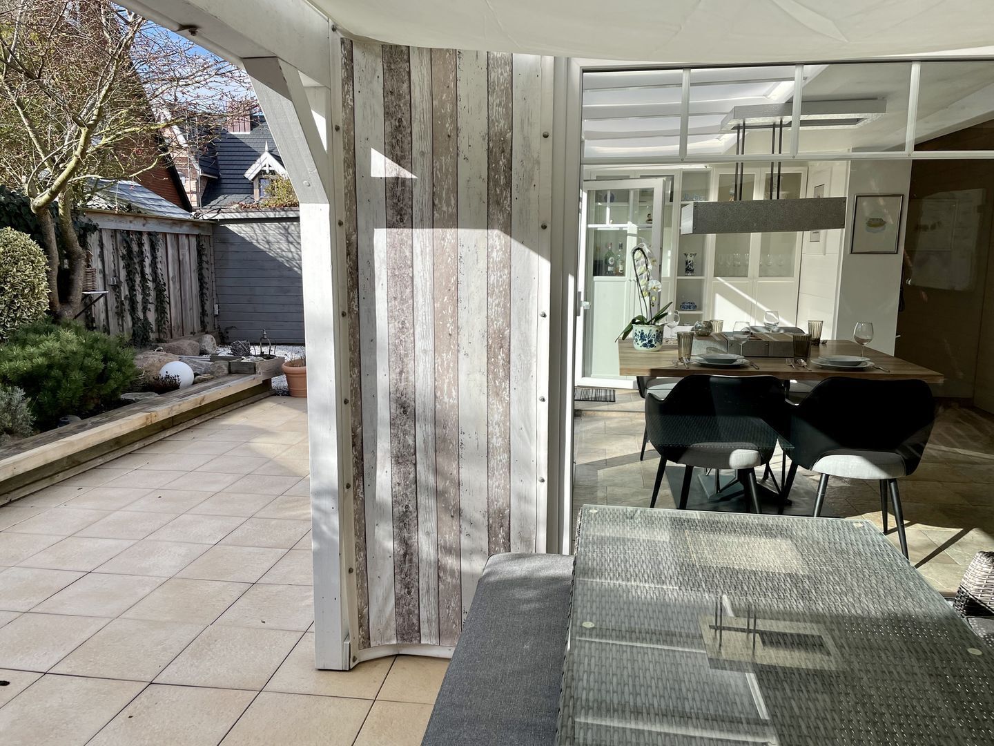 An open-plan living area with a dining table, chairs, and a view of the backyard.