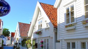 Eine Kopfsteinpflasterstraße gesäumt von weißen Gebäuden mit roten Ziegeldächern und Blumenkästen.