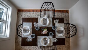 A dining table set for four with a marble top, black wire chairs, and a fluffy rug under the table. - In Heart of Stavanger BnB with Billiard & Sauna (Stavanger)