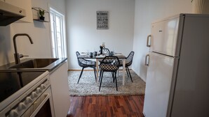 A compact kitchen with a dining table, chairs, a refrigerator, and a sink. - In Heart of Stavanger BnB with Billiard & Sauna (Stavanger)