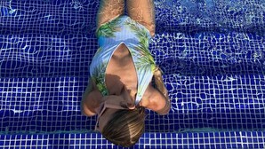 A person swimming in a pool with blue mosaic tiles. - Beautiful Villa in Cocotal Golf Punta Cana (Punta Cana)