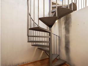 Staircase ascends to an upper level with a geometric pattern on the steps.