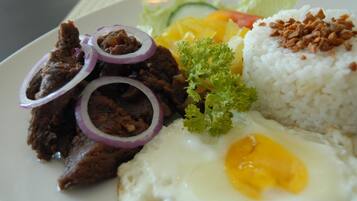 A plate of food with rice, beef, egg, and vegetables.
