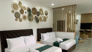 A hotel room with two beds, a large mirror, and decorative wall art.