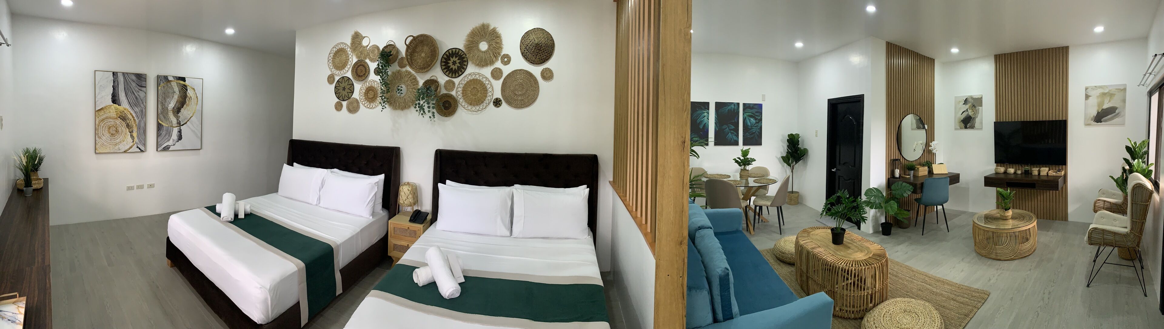 Une chambre d’hôtel avec deux lits, un coin repas et une télévision.