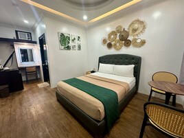Un dormitorio con cama, escritorio, silla y decoración en la pared.