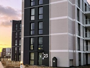 A modern multi-story residential building with a flat facade, large windows, and a visible unit number '23'. - Sandpiper (Wendtorf)