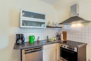 A kitchen with a dishwasher, stove, and microwave.
