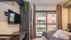 Une chambre d’hôtel moderne équipée d’un lit, d’un bureau, d’une télévision et d’une fenêtre avec des rideaux.