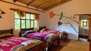 A room with two beds, a window with curtains, a wall mural, and a bathroom visible through an open door. - PONDOWASI LODGE (Angochagua)