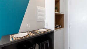 A modern kitchen with a black countertop, two white plates, and a wine glass.