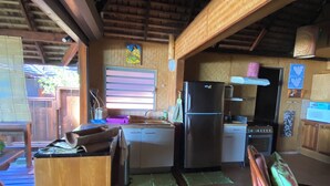 Una cocina con armarios de madera, un refrigerador y una estufa. Hay una mesa de comedor de madera y sillas.