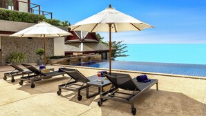 A poolside area with sun loungers, umbrellas, and a view of the ocean. - Villa Horizon (Kamala)