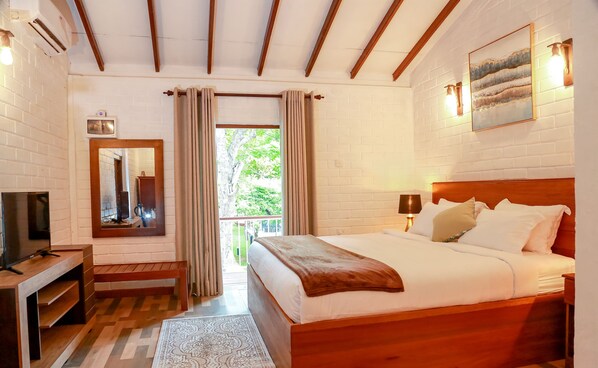 A bedroom with a wooden bed, a TV, a mirror, and a window with curtains. - Tepraas Sigiriya  (Diganpathaha)