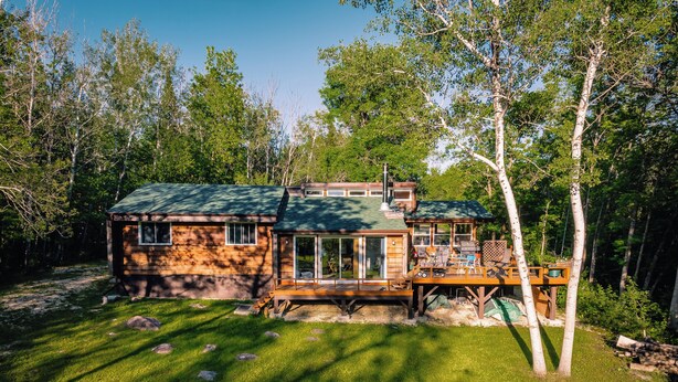 A cabin with a deck, large windows, and a chimney. - Lakeview cabin, 3 min walk to the beach! (Grand Marais)