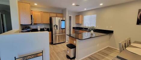 A modern kitchen with stainless steel appliances, wooden cabinets, and a central island.