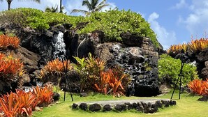 A tropical garden with a waterfall, lush greenery, and a pool. - Ocean view room, Beachfront Kauai Beach Resort, Jacuzzis, 4 pools, restaurants (Lihue)
