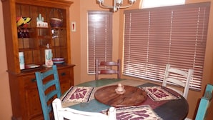 A dining area with a wooden table, chairs, and a cabinet with decorative items.