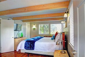 Cozy retreat with a large bed, wooden nightstands, and a wall-mounted lamp.