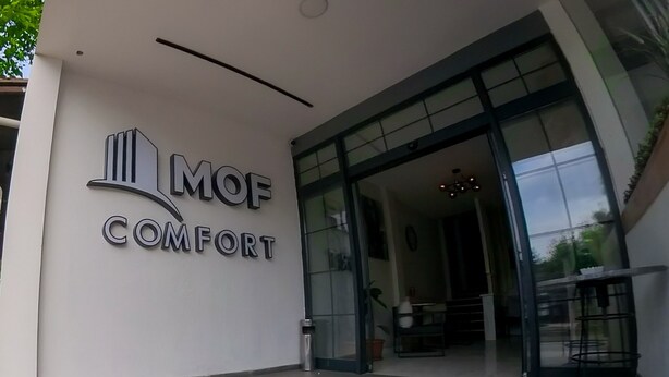 The entrance to MOF Comfort with a modern design, including a glass door and a small outdoor seating area. - MOF Comfort Edirne (Edirne)