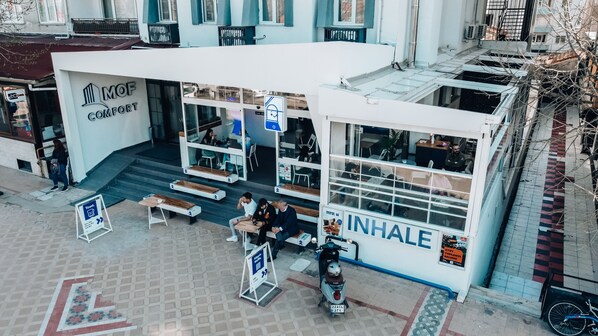 Un edificio moderno con una cafetería llamada "Inhale" y un letrero de "Moof Comfort".