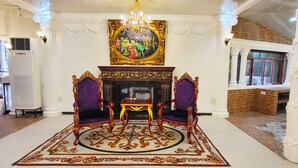 A grand room with ornate furniture, a chandelier, and a large painting on the wall. - Mancion Bakasyunan Resort San Pablo (San Pablo)