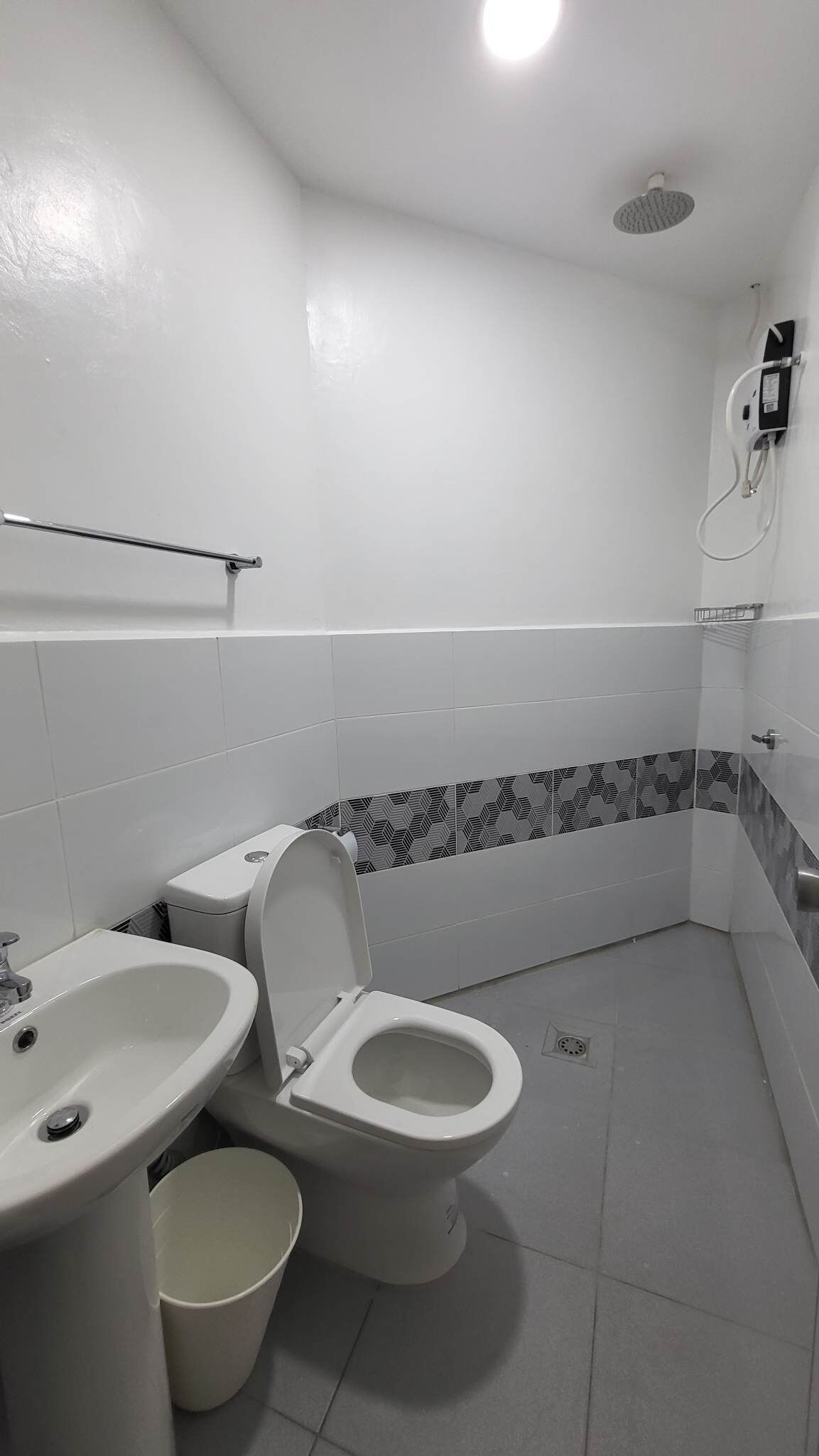 A bathroom with a toilet, sink, and shower.