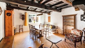 A dining area with a wooden table and chairs, a sofa, and a bookshelf. - Casa Merlot in Caslano for 4 (Caslano)