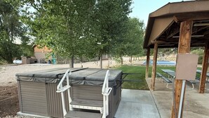 A covered outdoor seating area with a grill and a barbecue station.