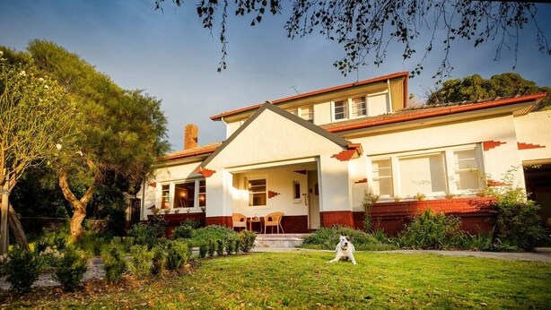 A two-story house with a red roof and white walls, a front porch, and a well-maintained lawn. - Amazing 1934 deco house. (Wonthaggi,)